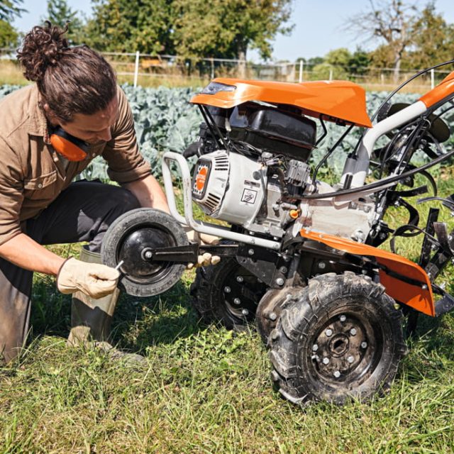 Čovek koji podešava benzinsku frezu